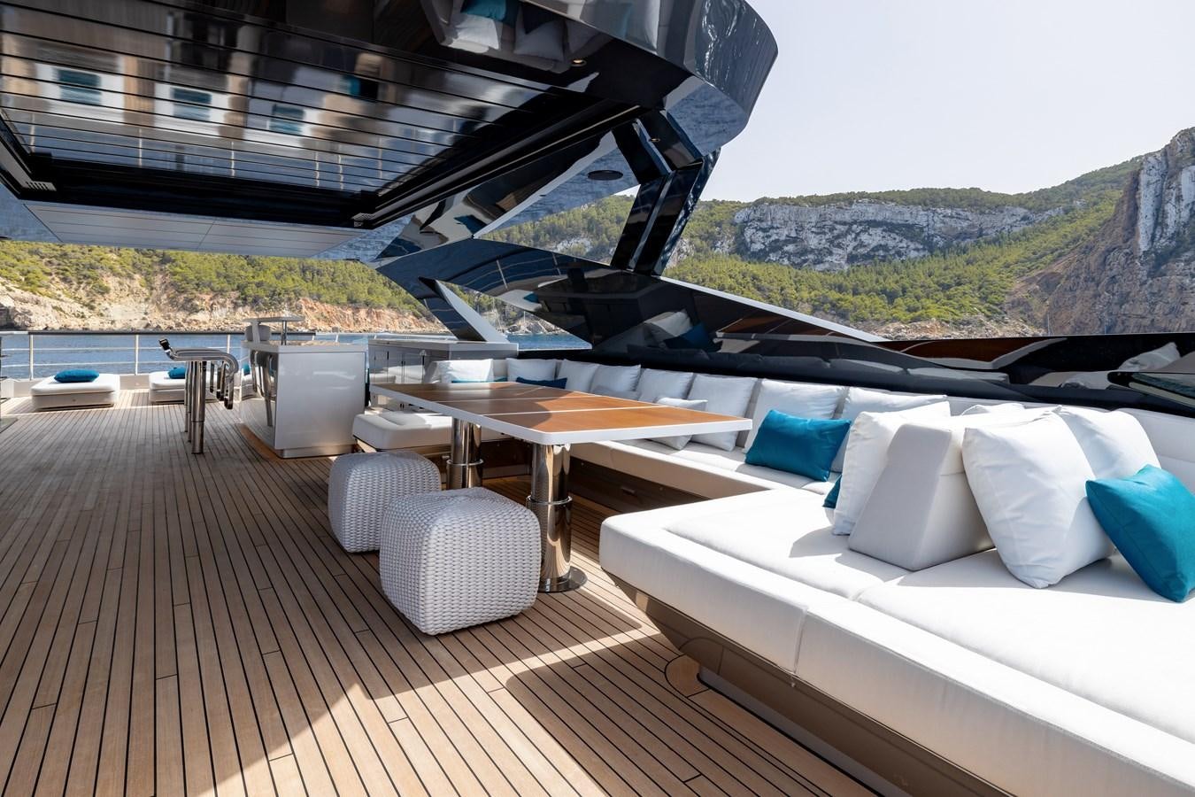 a deck with a table and chairs on it aboard NO STRESS Yacht for Sale