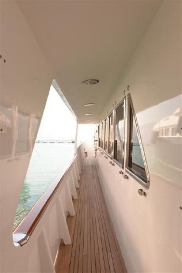 a long hallway with a row of white cabinets and a large mirror aboard MISTER P Yacht for Sale