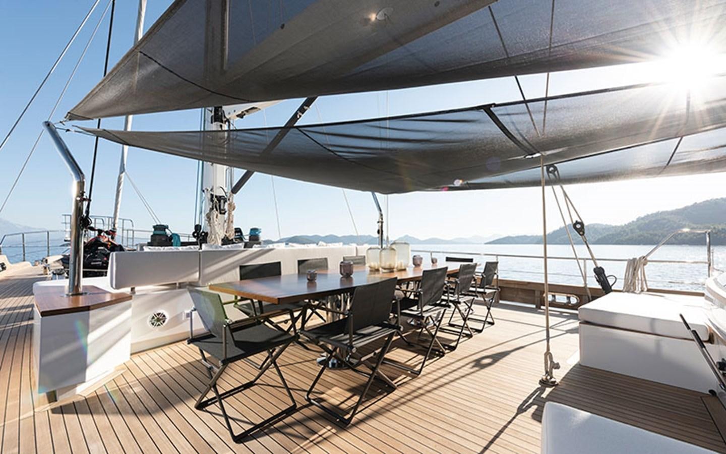 a deck with a table and chairs on it aboard ATLANTIKA Yacht for Sale