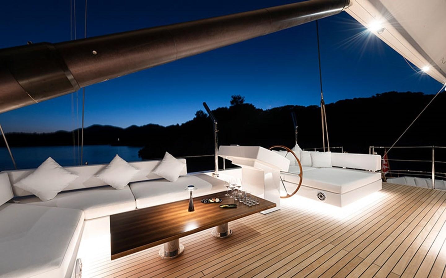 a room with a large bed and a table with chairs on it aboard ATLANTIKA Yacht for Sale