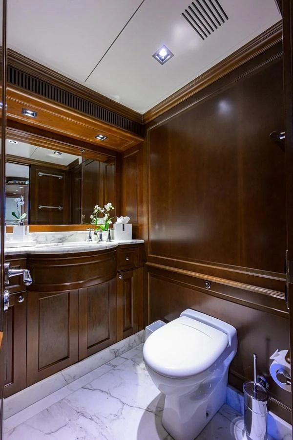 a bathroom with a toilet and a large mirror aboard ARTHUR’S WAY Yacht for Sale