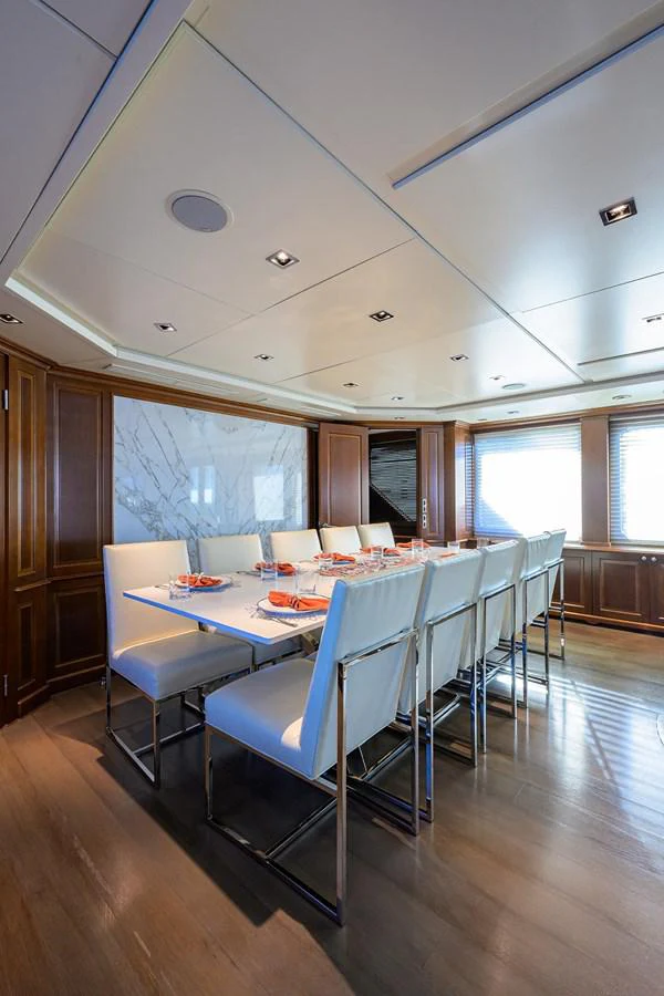 a dining room with blue chairs aboard ARTHUR’S WAY Yacht for Sale