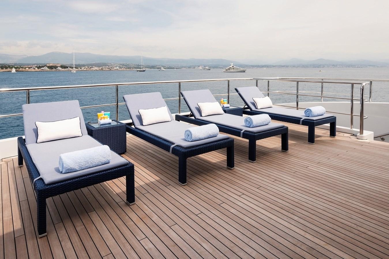 a deck with a table and chairs on it aboard MY LEGACY Yacht for Sale
