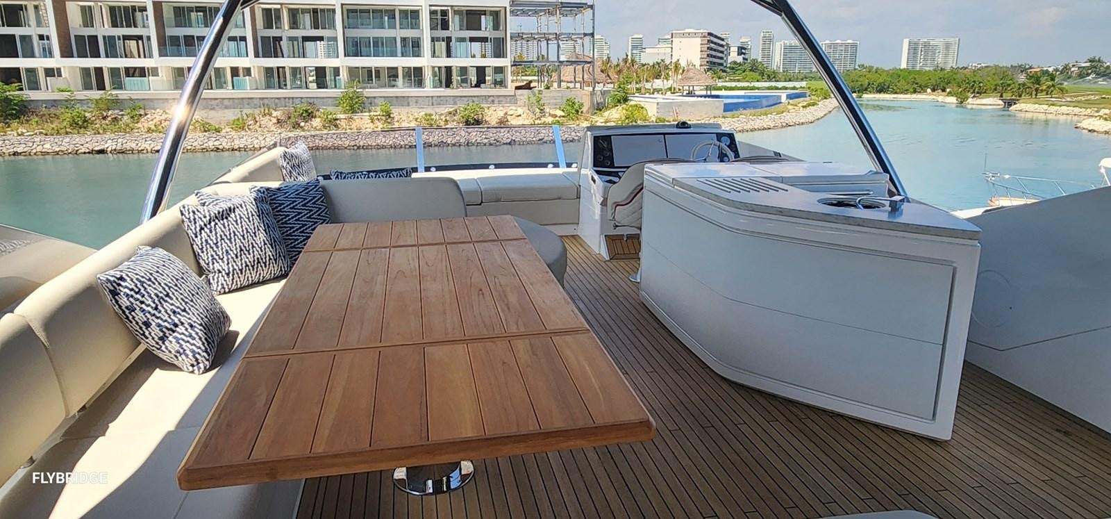 a deck with a table and chairs on it aboard EL 5 MARES Yacht for Sale