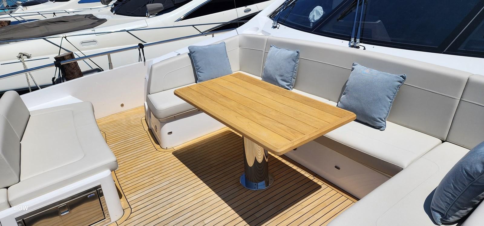 a wooden table with a white couch aboard EL 5 MARES Yacht for Sale