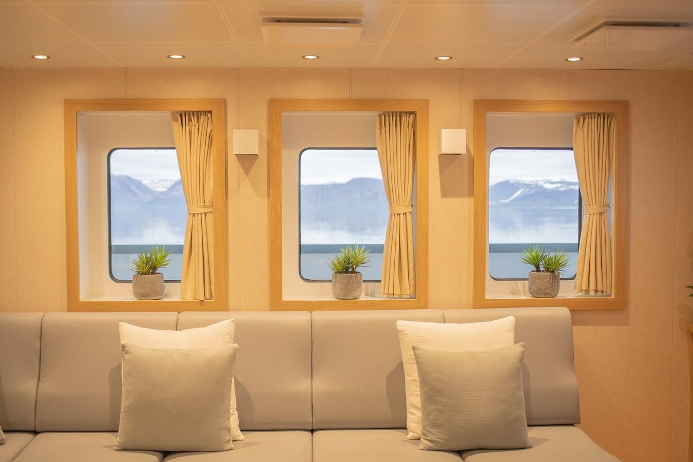 a room with a couch and a window aboard WINGMAN Yacht for Sale