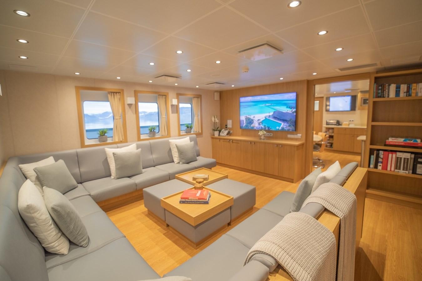 a living room with a large screen aboard WINGMAN Yacht for Sale
