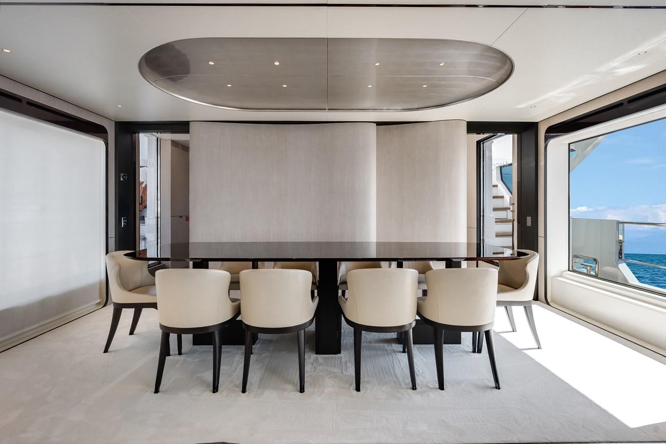 a room with a table and chairs aboard AMICO Yacht for Sale