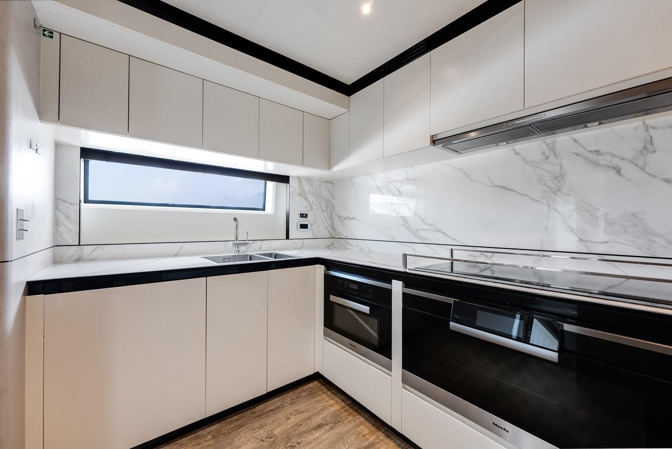 a kitchen with white cabinets aboard AMICO Yacht for Sale