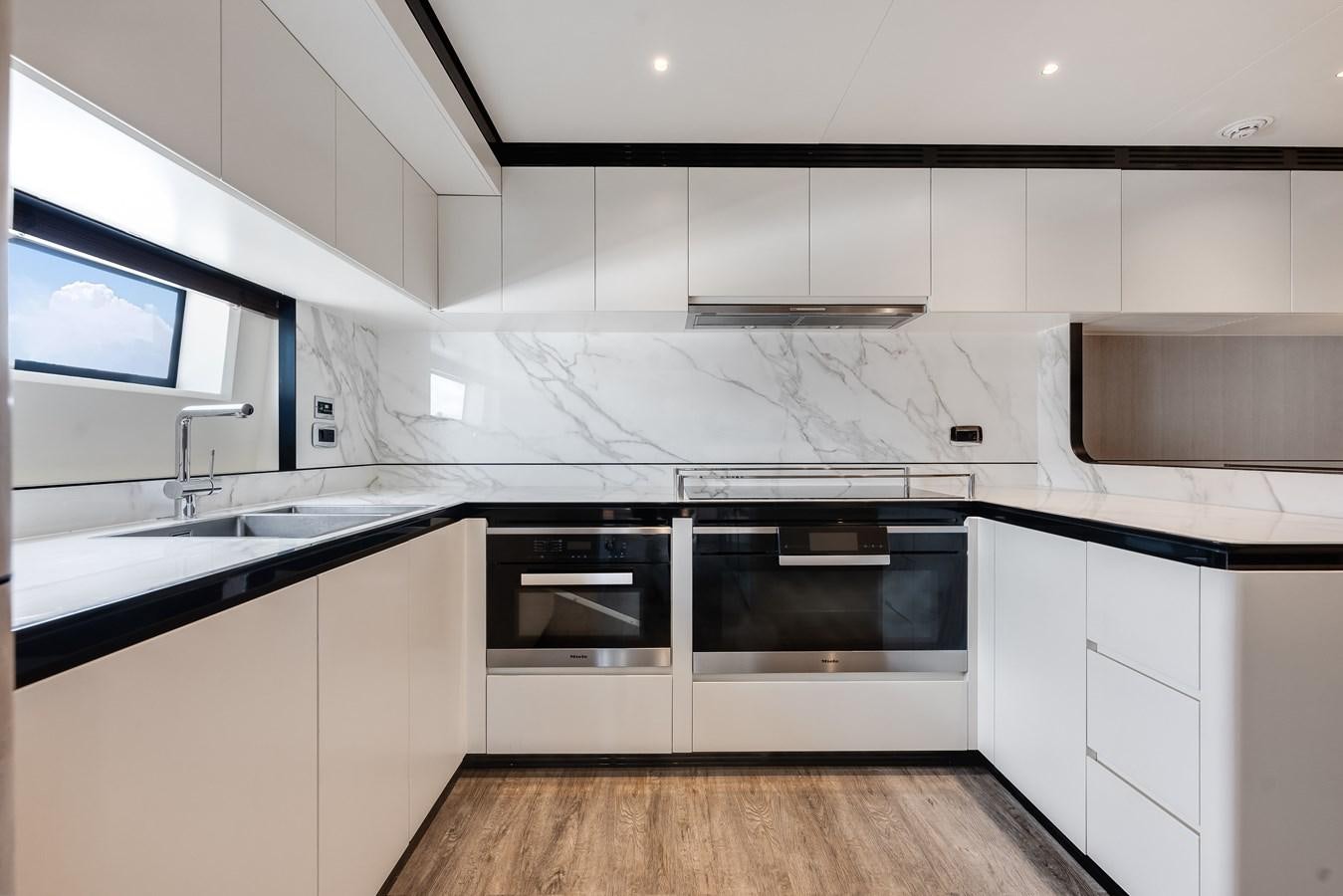 a kitchen with white cabinets aboard AMICO Yacht for Sale