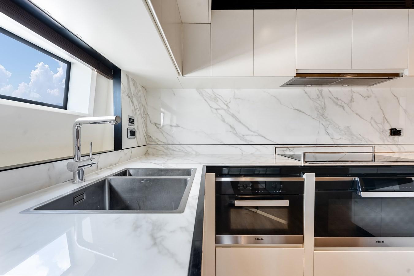 a kitchen with white cabinets aboard AMICO Yacht for Sale