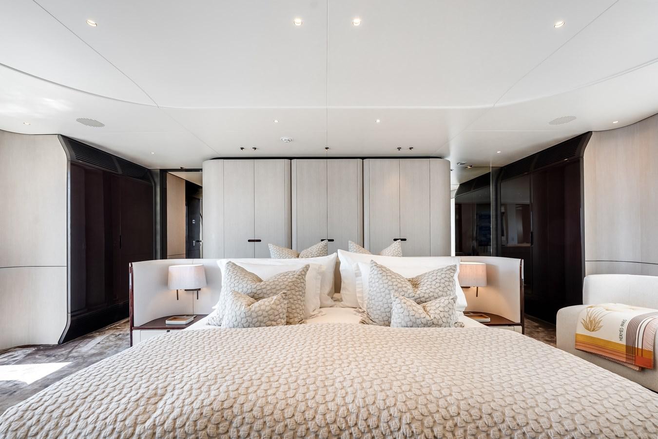 a large bed with white sheets aboard AMICO Yacht for Sale
