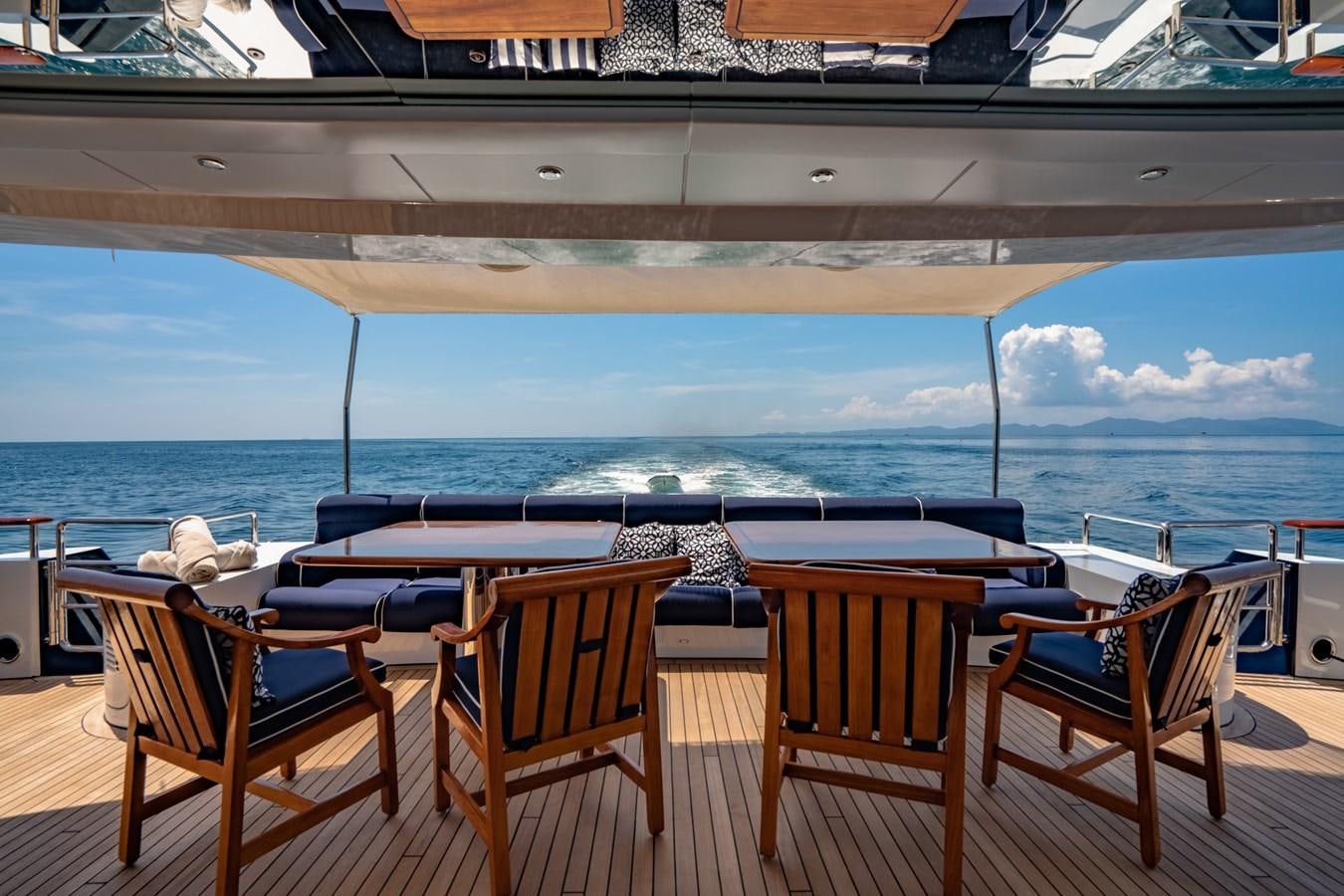 a deck with chairs and tables on it by a large body of water aboard LADY AZUL Yacht for Sale