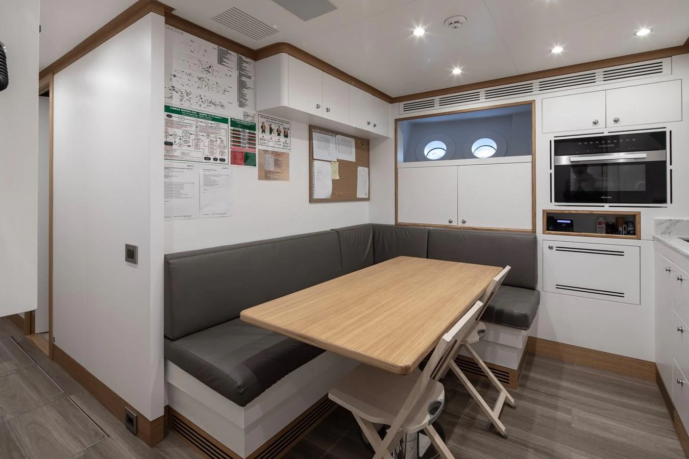 a kitchen with a table and couch aboard LEXSEA Yacht for Sale