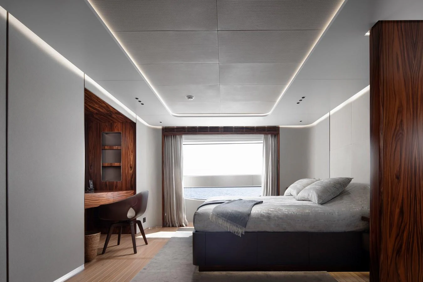 a bedroom with a bed and a desk aboard LEXSEA Yacht for Sale