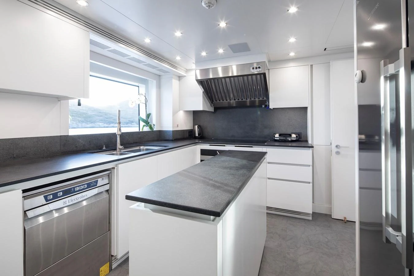 a kitchen with white cabinets aboard LEXSEA Yacht for Sale