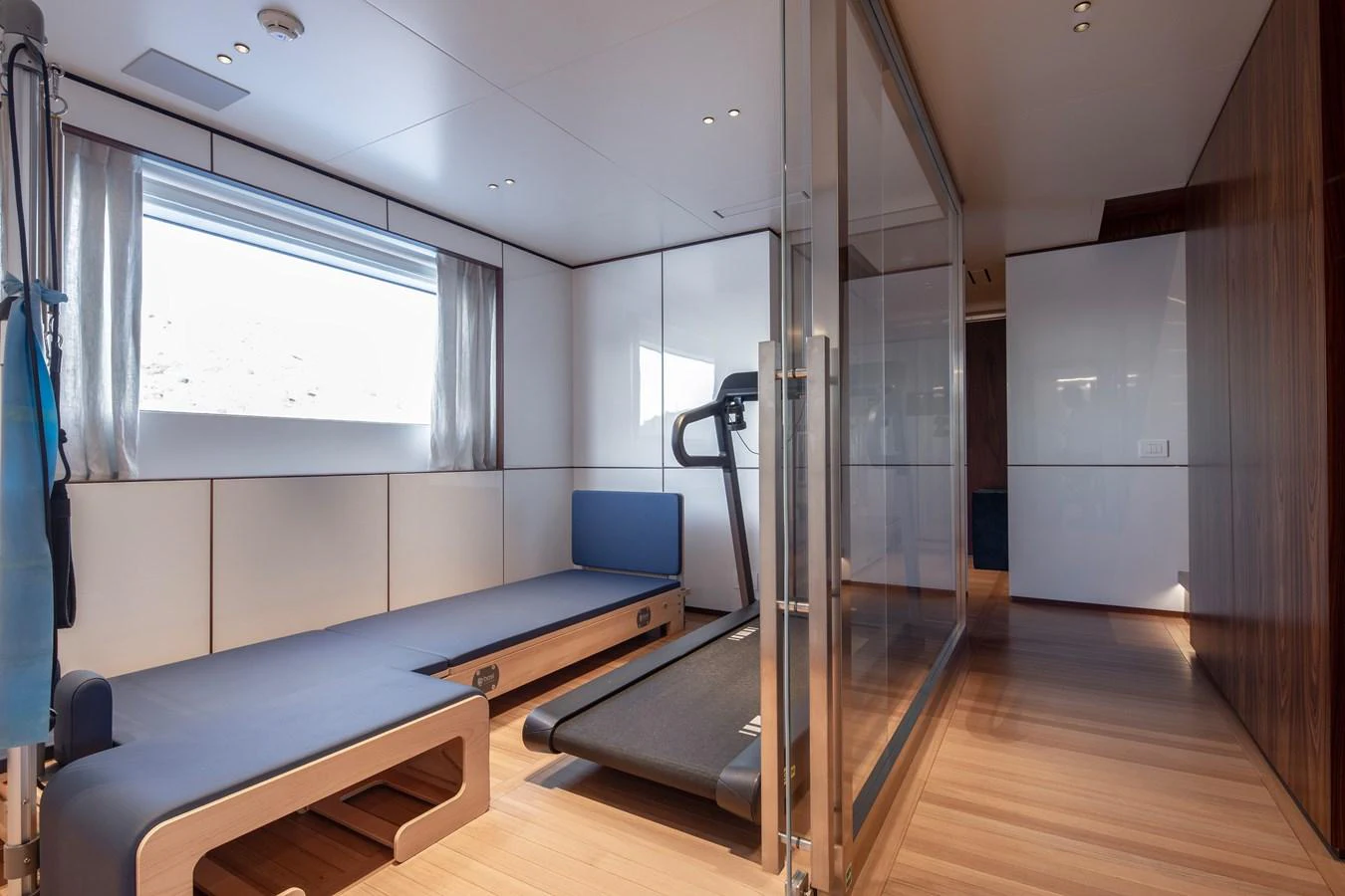 a room with a blue couch and a large mirror aboard LEXSEA Yacht for Sale