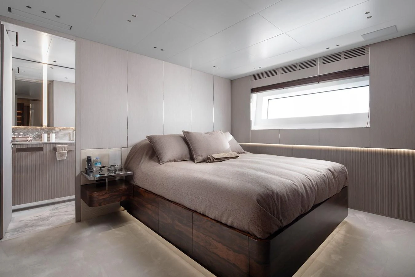 a bedroom with a bed and a table aboard LEXSEA Yacht for Sale