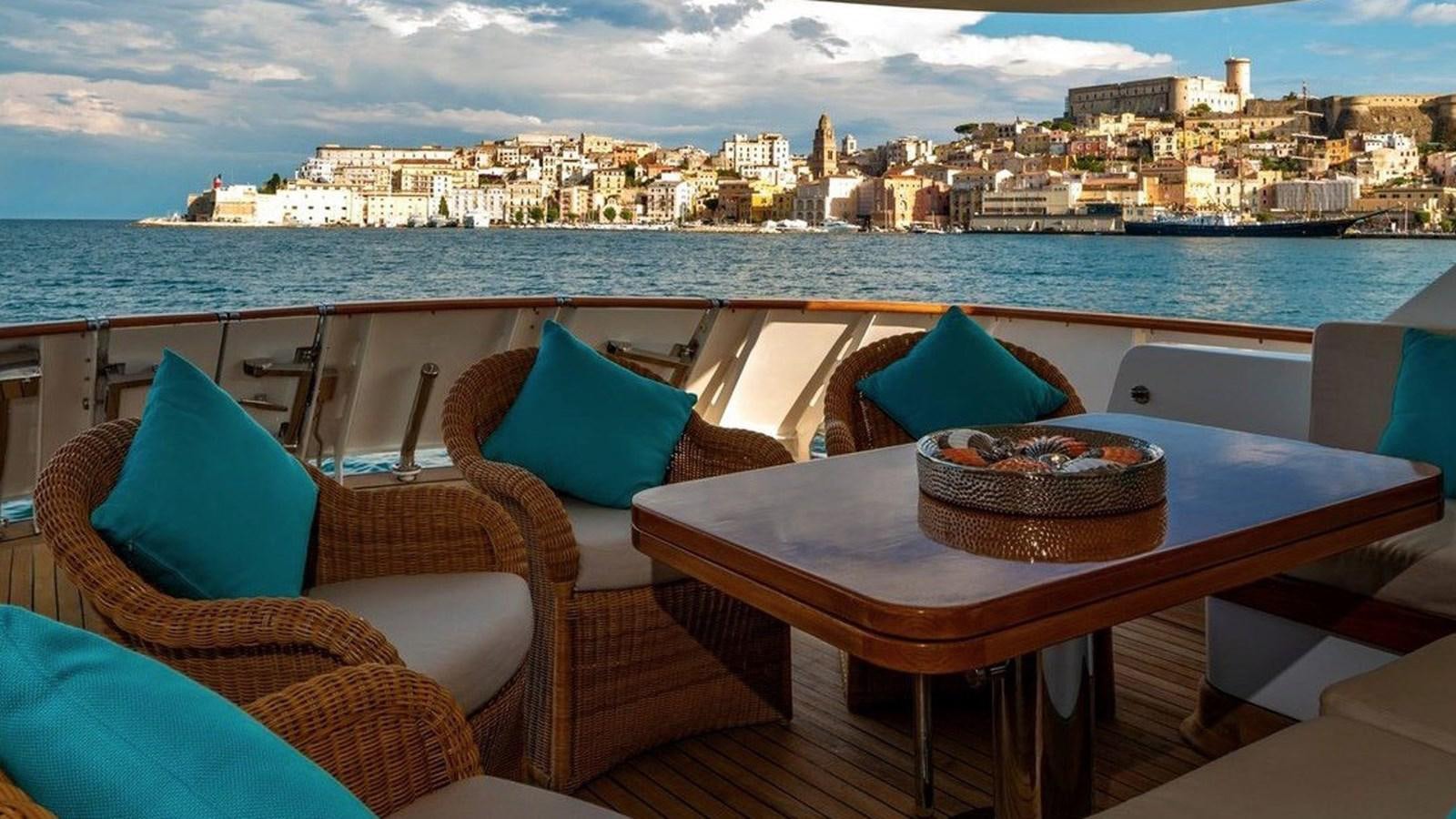 a table with chairs and a view of a city aboard NIGHTFLOWER Yacht for Sale