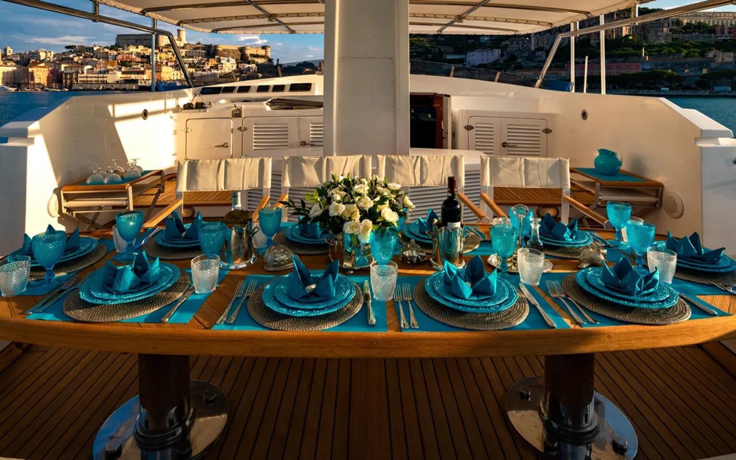 a table with many blue and white glasses and flowers on it aboard NIGHTFLOWER Yacht for Sale