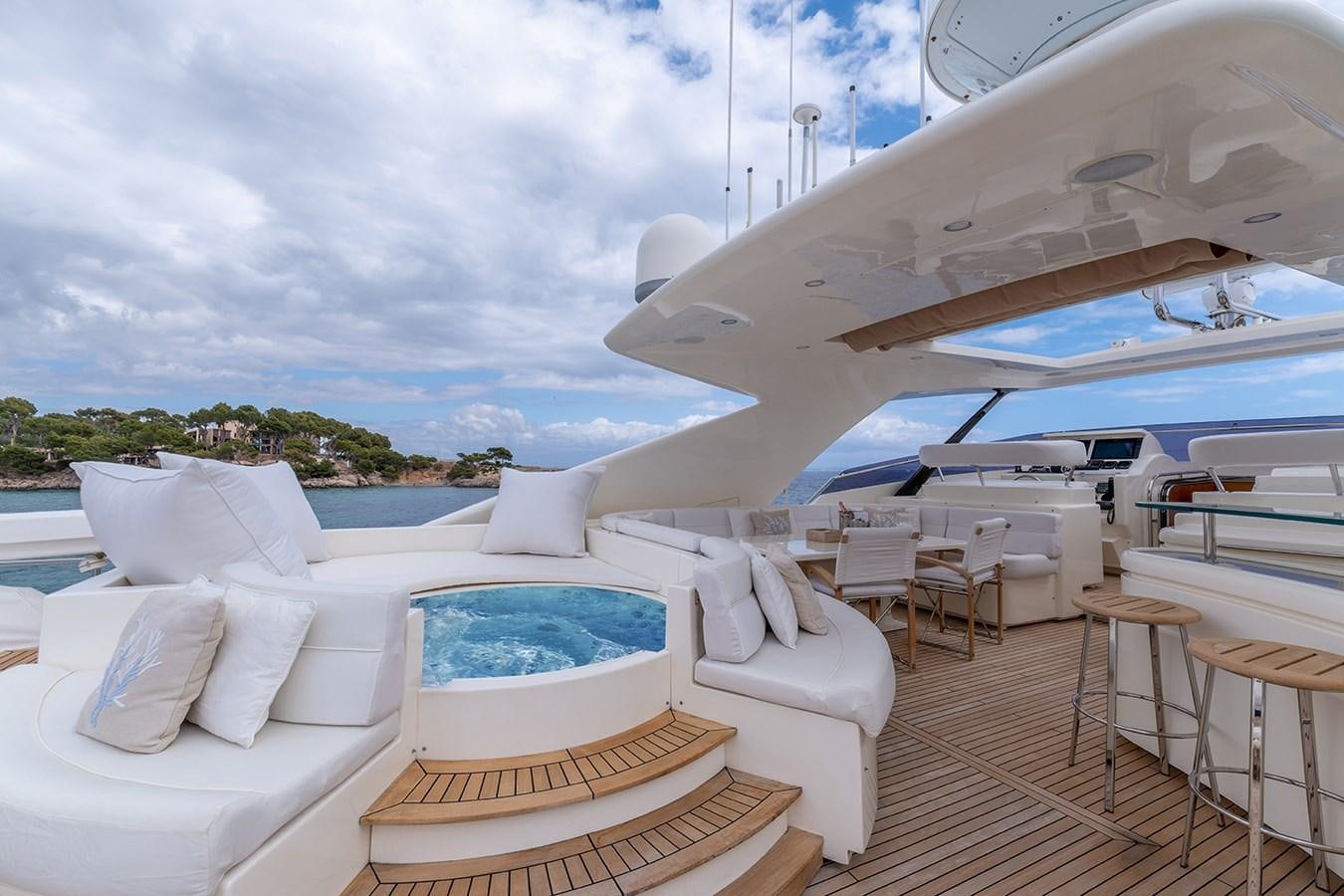 a lounge area with a large white lounge chair and a large white yacht aboard MALEN Yacht for Sale