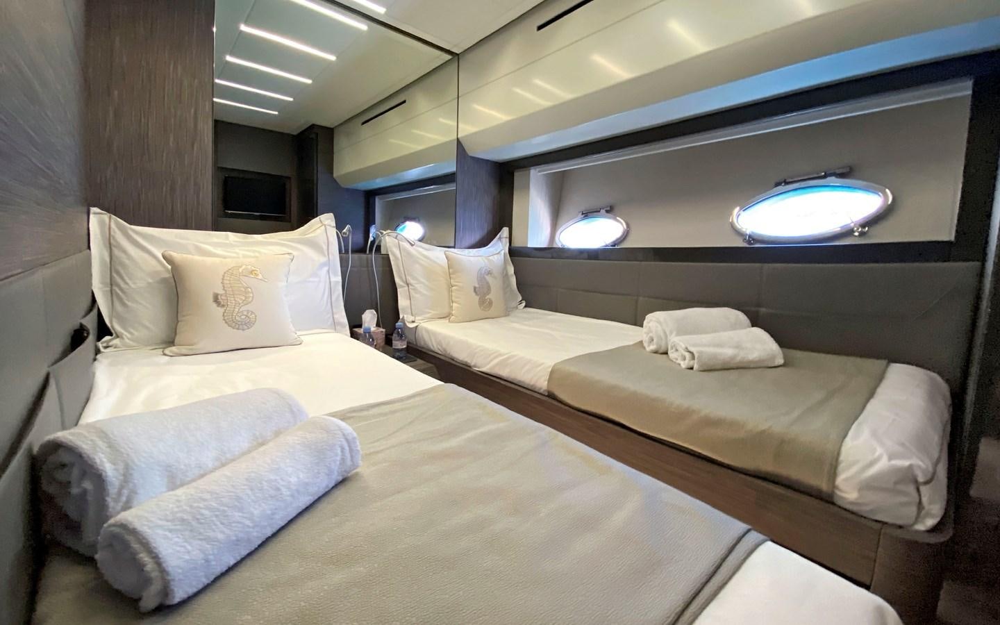 a room with beds and a large mirror aboard UPTOWN GIRL Yacht for Sale