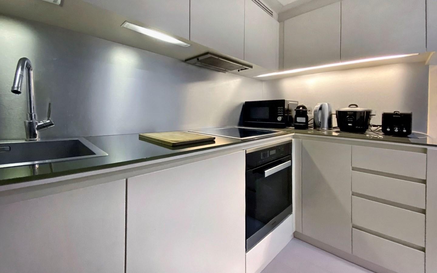 a kitchen with white cabinets aboard UPTOWN GIRL Yacht for Sale