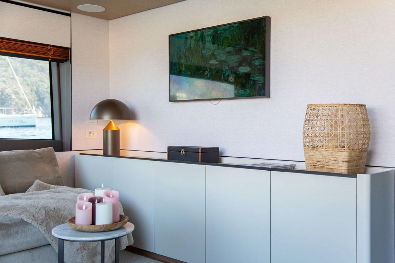 a room with a couch and a lamp on a table aboard 2020 BLUEGAME BGX70 #02 Yacht for Sale