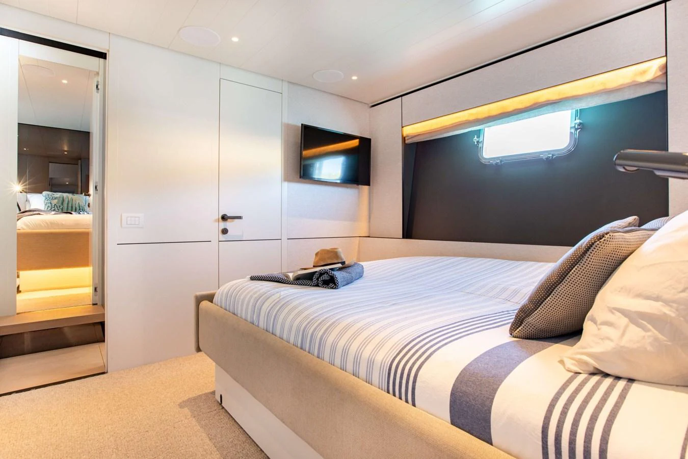a bedroom with a bed and a window aboard 2020 BLUEGAME BGX70 #02 Yacht for Sale
