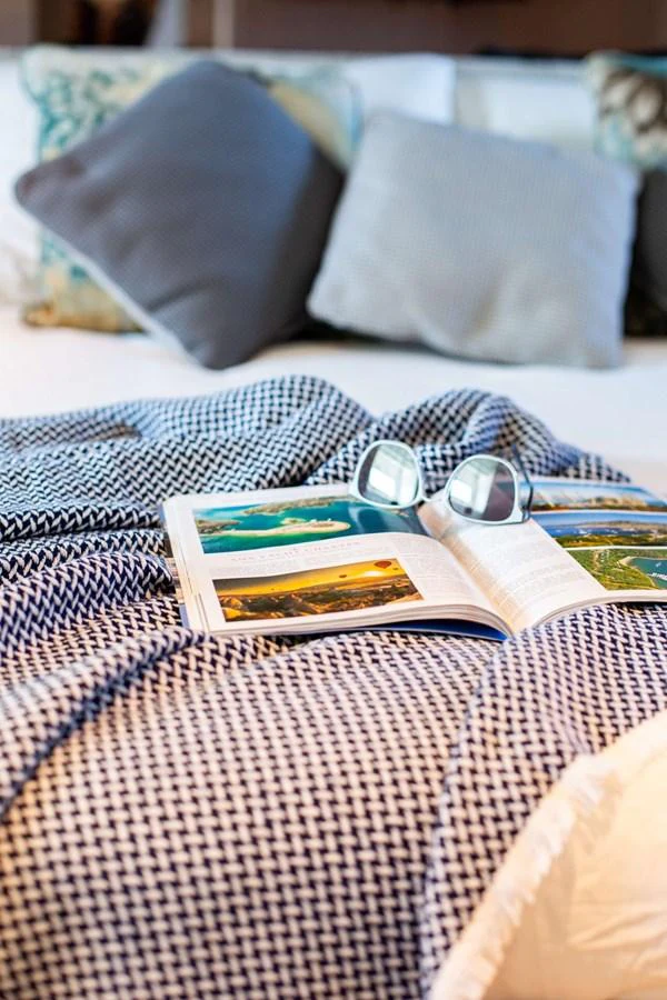 a bottle of liquor on a bed aboard 2020 BLUEGAME BGX70 #02 Yacht for Sale