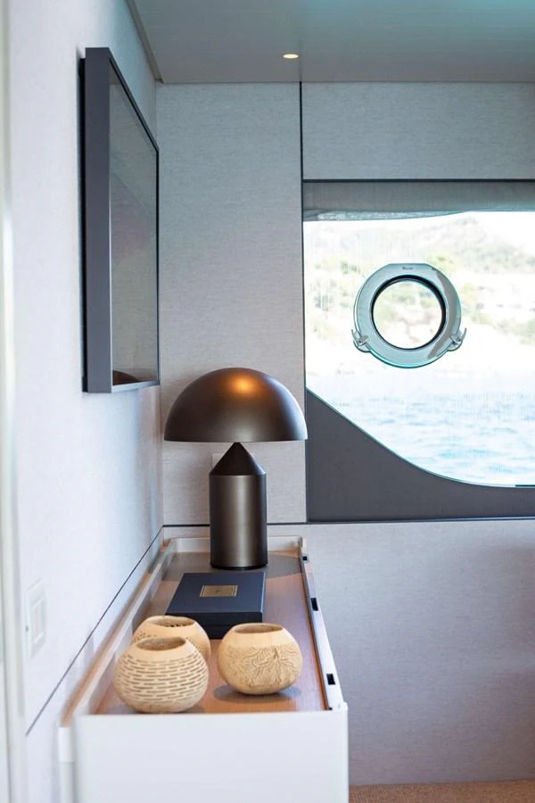 a table with a lamp and a book on it aboard 2020 BLUEGAME BGX70 #02 Yacht for Sale