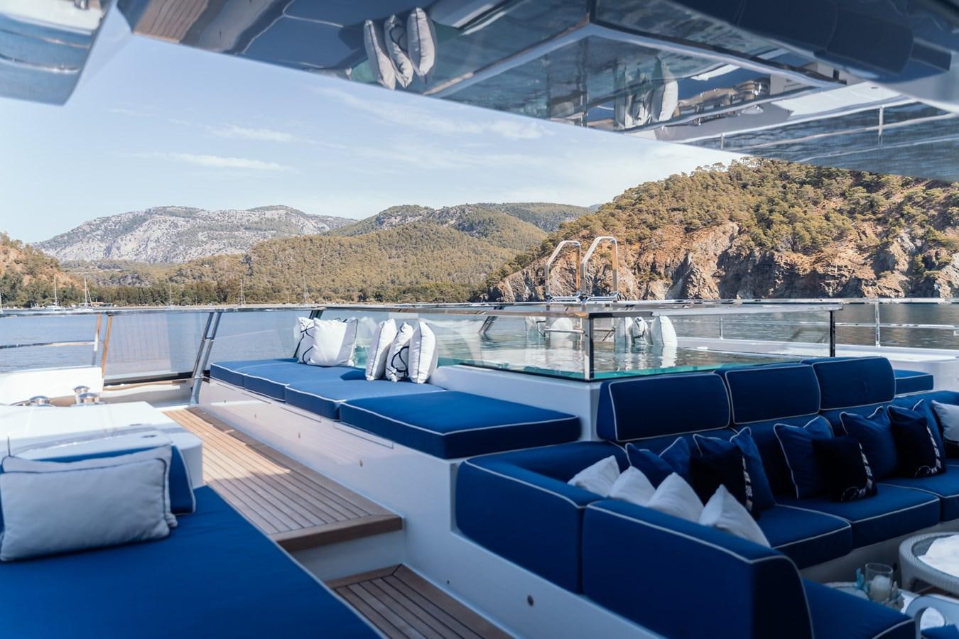 a pool with a view of mountains and water aboard ALULIM Yacht for Sale