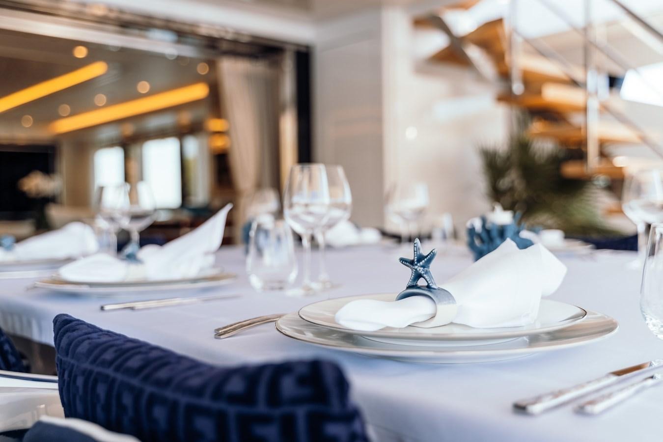 a table with plates and glasses aboard ALULIM Yacht for Sale