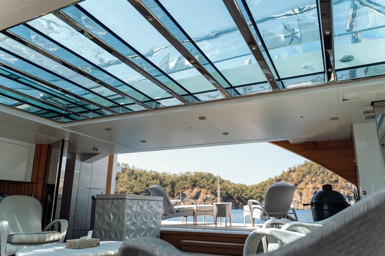 a covered patio with a table and chairs and a large umbrella aboard ALULIM Yacht for Sale
