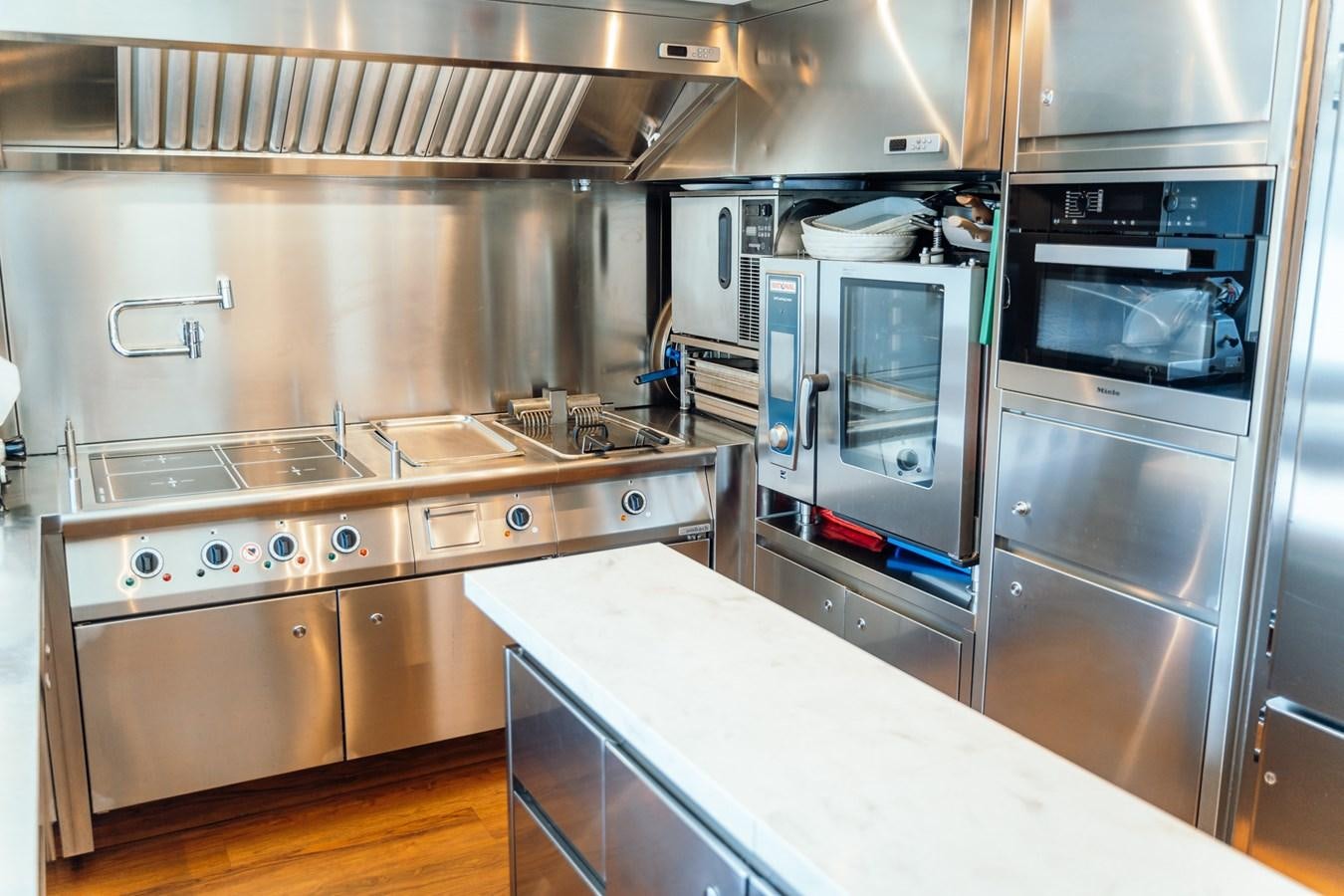 a kitchen with stainless steel appliances aboard ALULIM Yacht for Sale