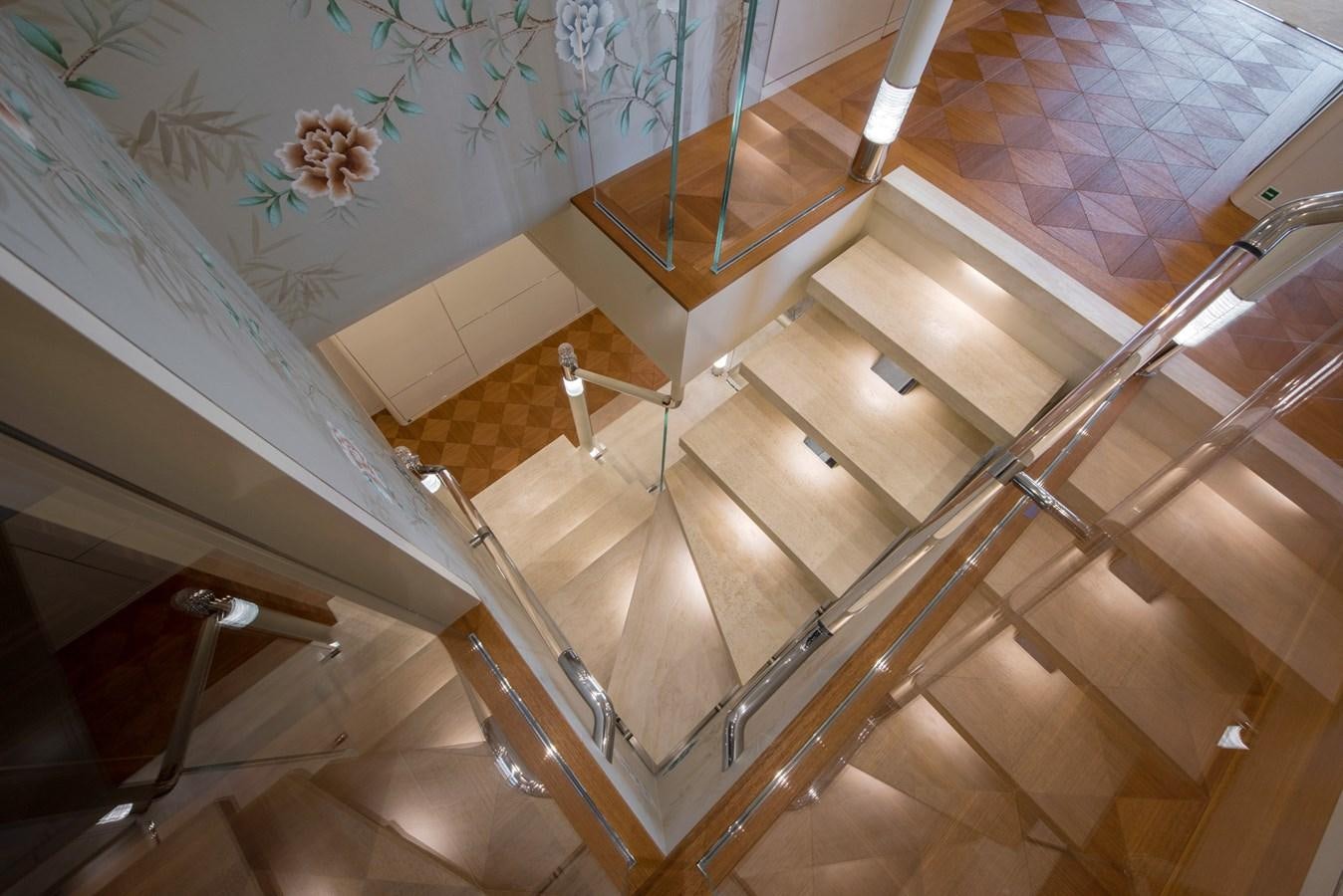a staircase with a glass railing aboard ALULIM Yacht for Sale