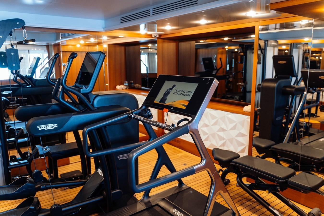 a room with blue seats and a black framed picture on the seat aboard ALULIM Yacht for Sale