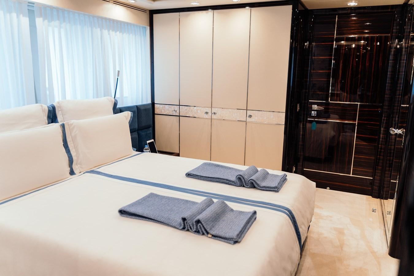 a bed with white sheets and pillows aboard ALULIM Yacht for Sale