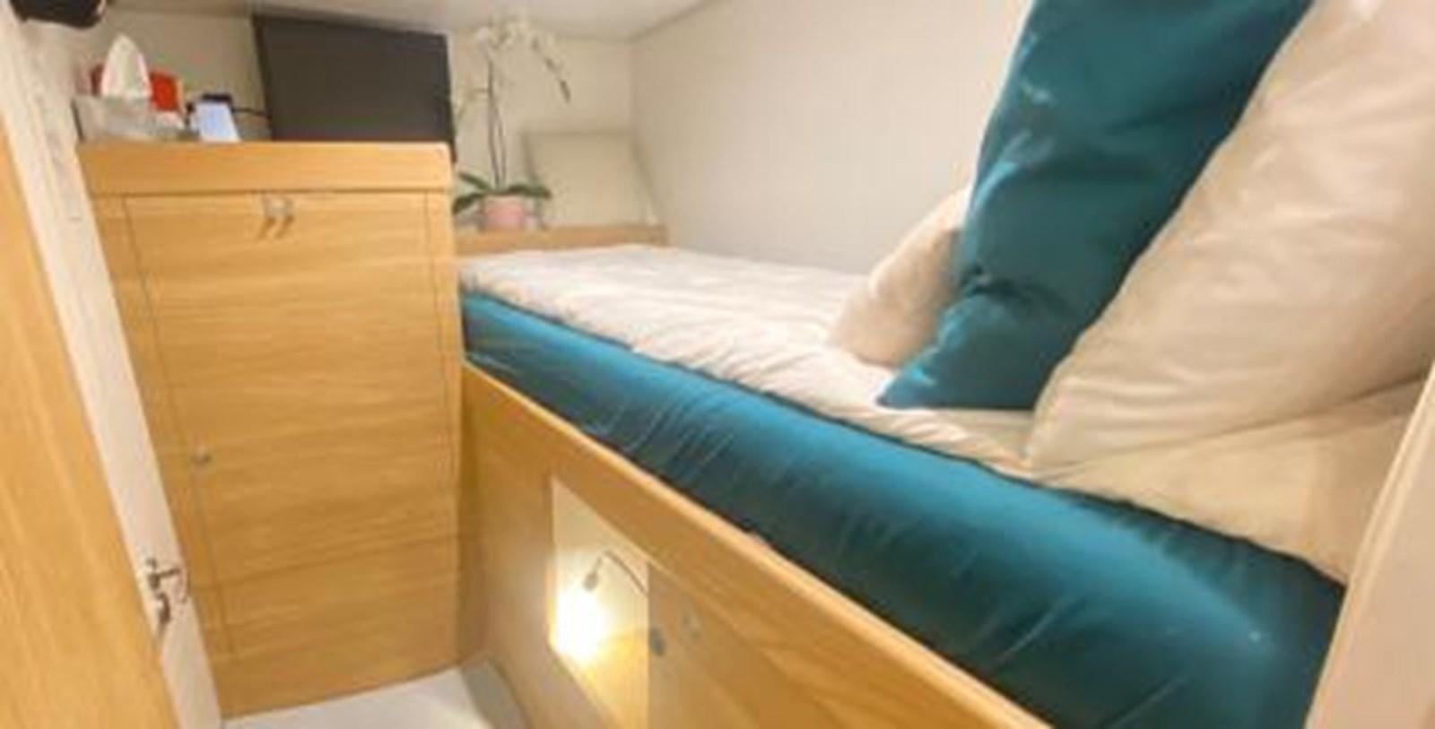a bed with a blue comforter aboard LADY NORA Yacht for Sale
