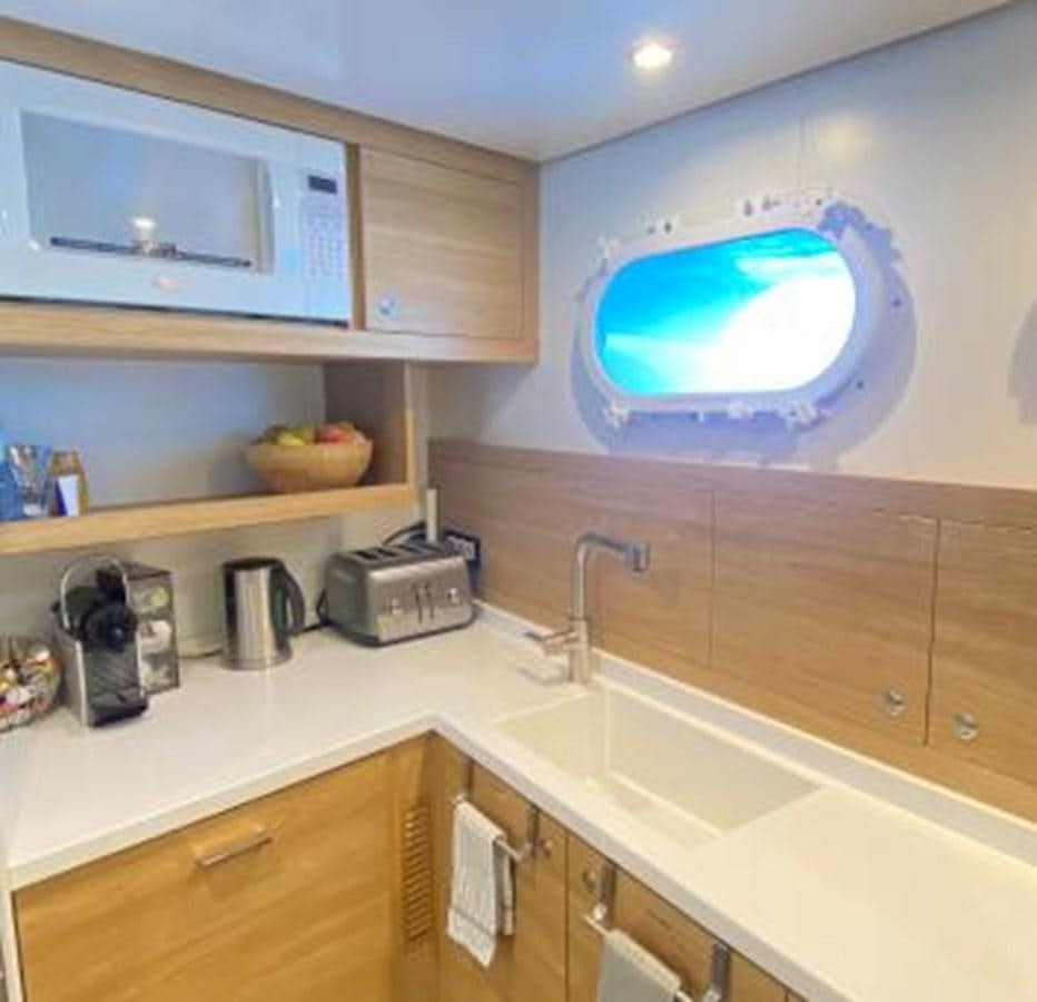 a kitchen with a large television aboard LADY NORA Yacht for Sale