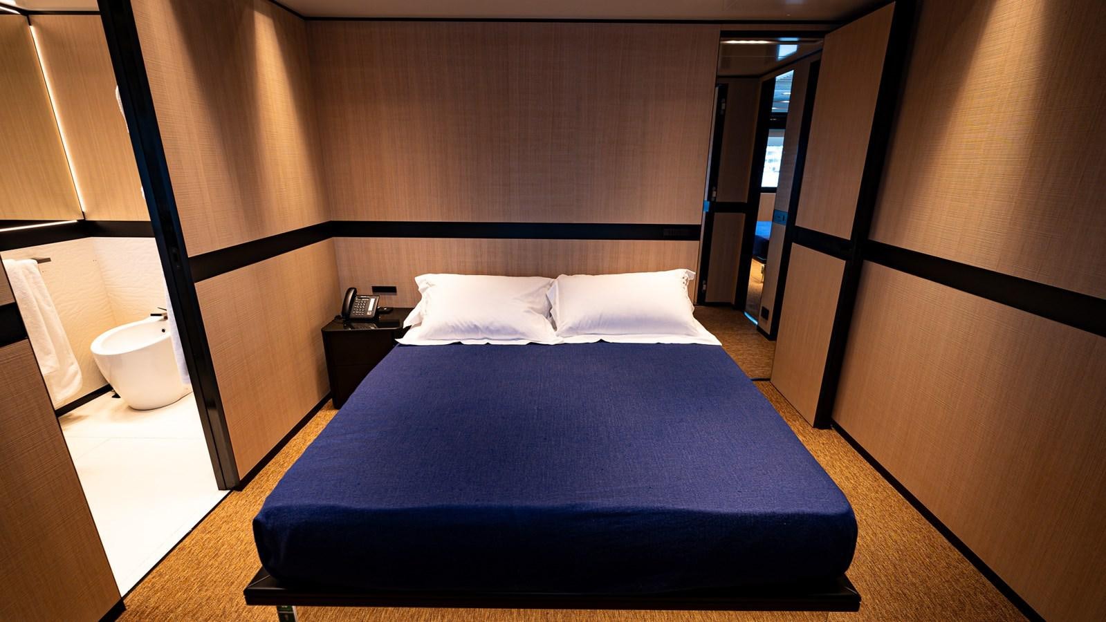 a bed with a blue sheet aboard LASTOCHKA Yacht for Sale