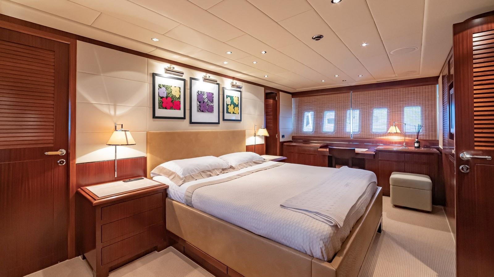 a bedroom with a bed and desk aboard POPEYE Yacht for Sale