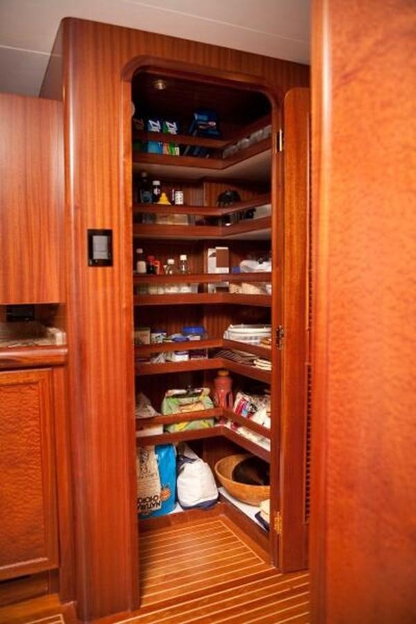 a wooden cabinet with shelves and items on it aboard AL DI LA Yacht for Sale
