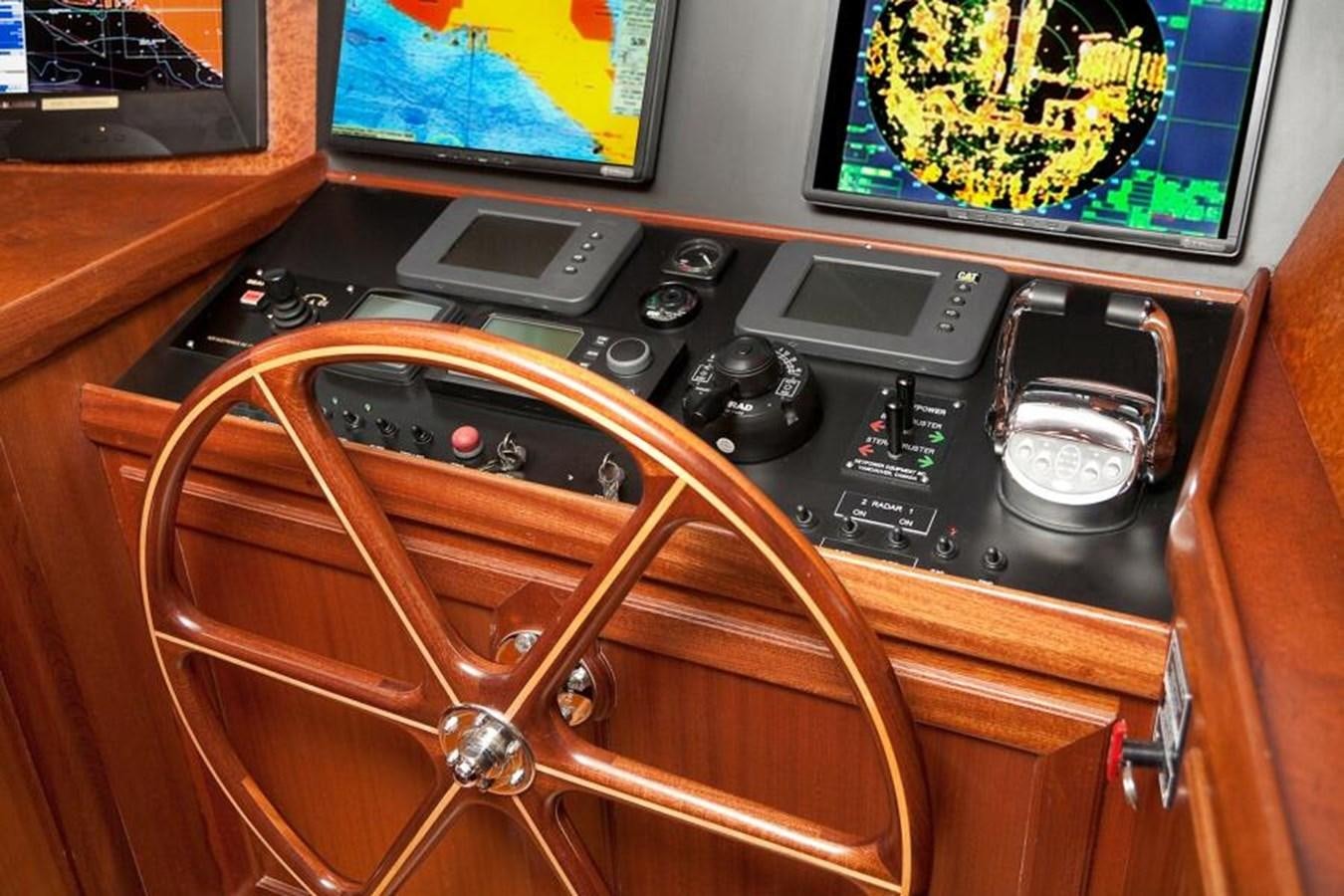 a wooden chair with a radio and game console on it aboard AL DI LA Yacht for Sale