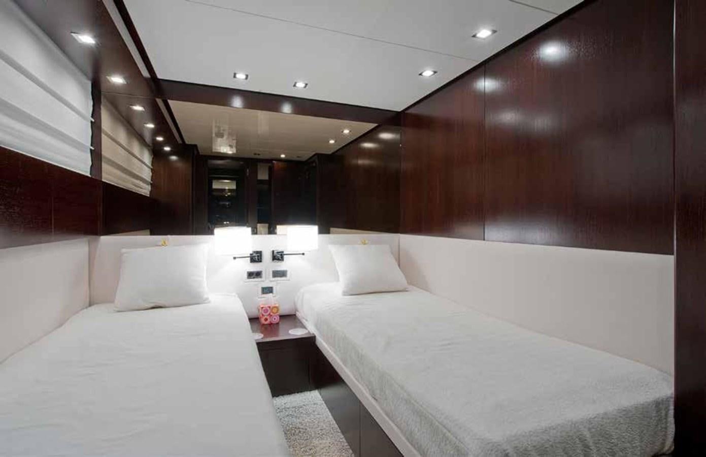 a room with beds and a table aboard 2009 SANLORENZO SL88 #541 Yacht for Sale