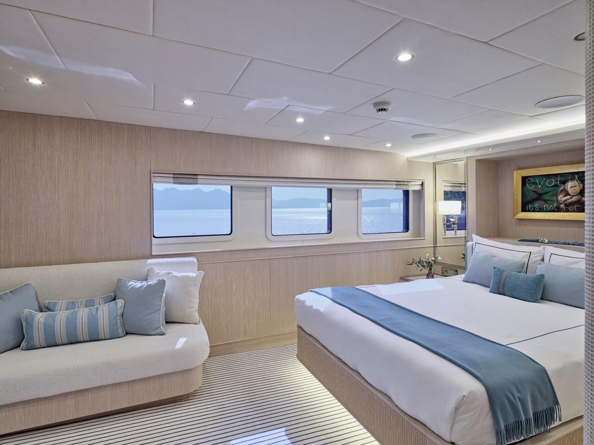 a room with a bed and a couch aboard AKULA Yacht for Sale