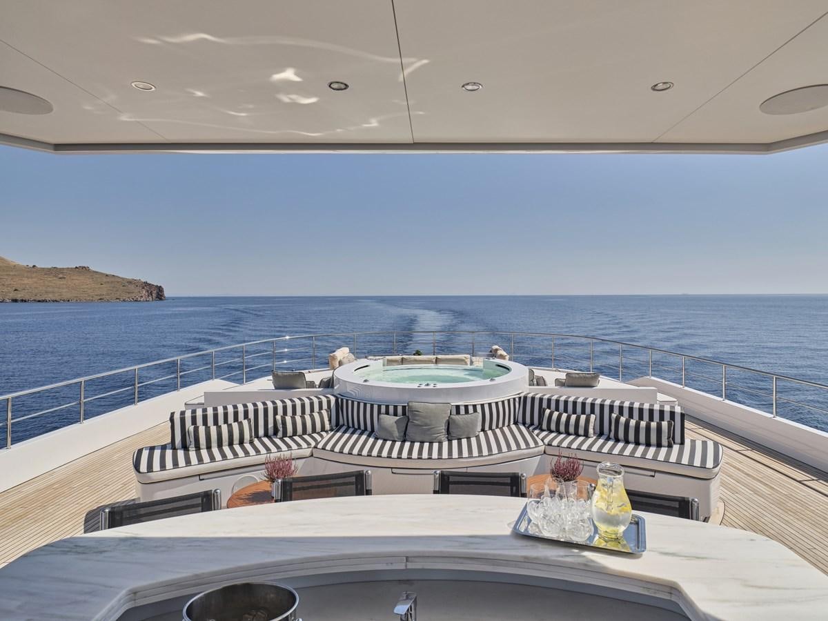a balcony with a large body of water and a large boat on it aboard AKULA Yacht for Sale