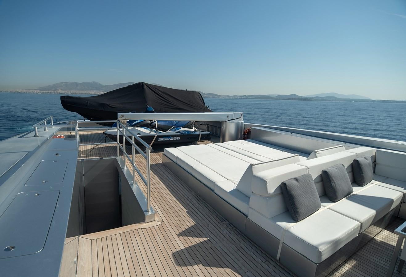 a deck with a view of the ocean and a large boat aboard TIN TIN Yacht for Sale