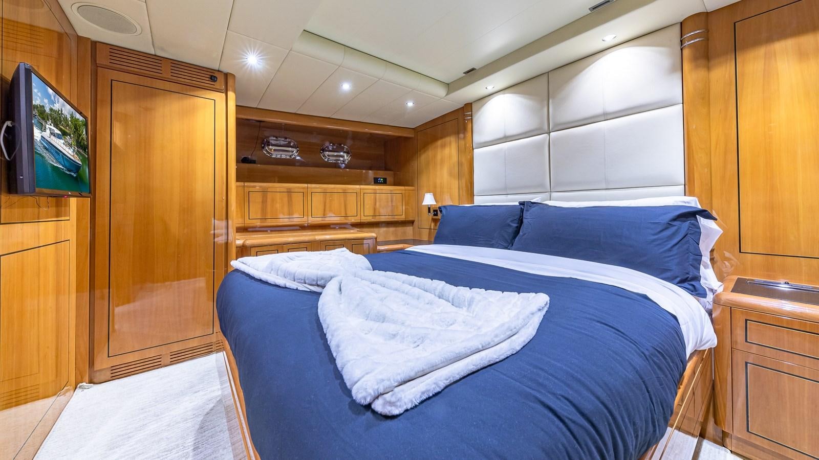 a bed with a blue comforter aboard HAPPY Yacht for Sale