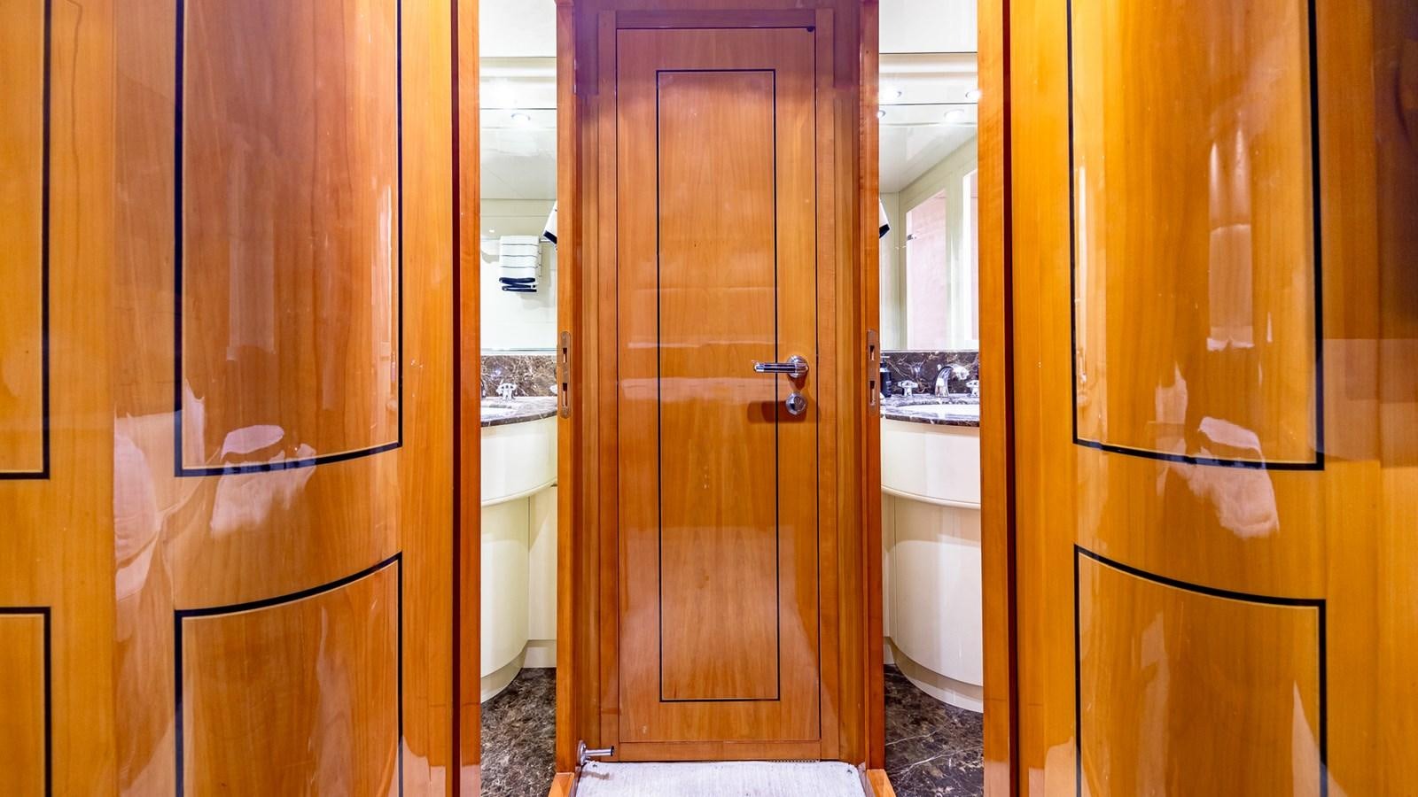 a bathroom with a wood door aboard HAPPY Yacht for Sale